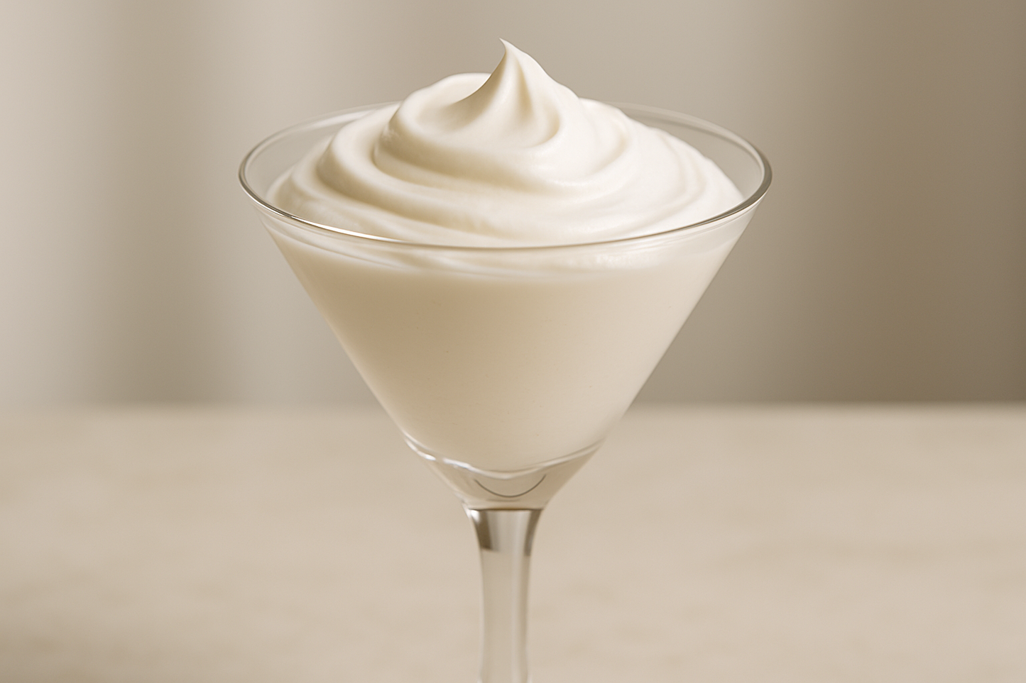 cocktail martini glass, high stem filled to the rim with a creamy body butter on a vanity. close up of the glass not to much background